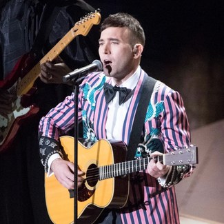 Sufjan Stevens performing with a guitar